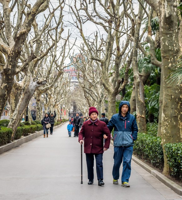 A man taking his mother for a walk in Fuxing Park in Shanghai