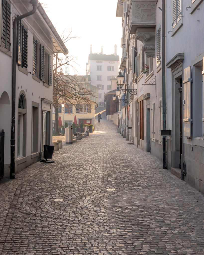 A cobbled alleyway in Zurich in soft sunlight
